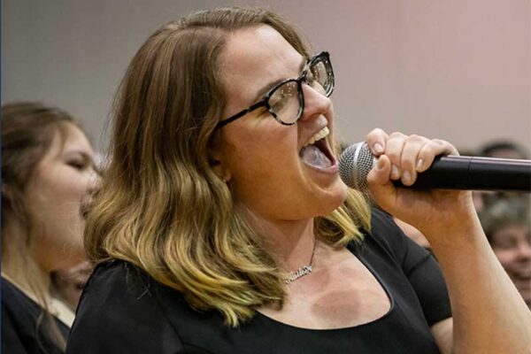 A County College of Morris student sings into a handheld microphone.