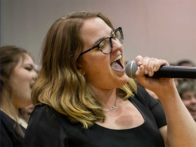 A County College of Morris student sings into a handheld microphone.