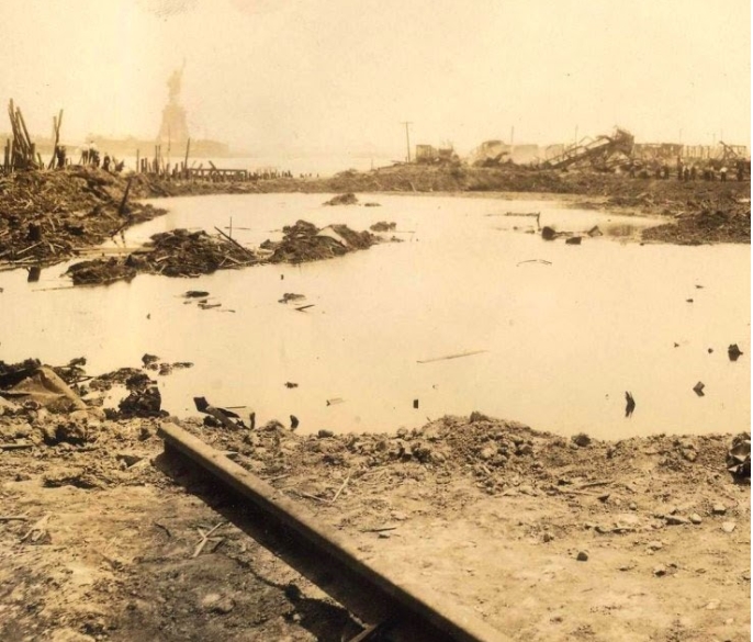 photo of the aftermath of the Black Tom explosion with the statue of Liberty in the background