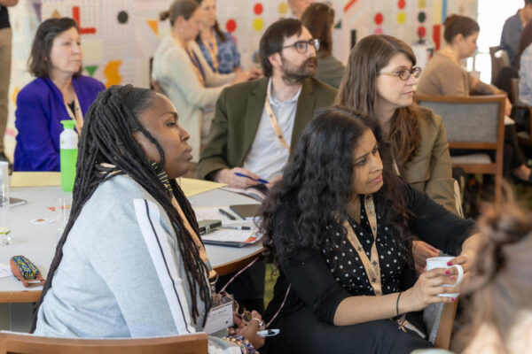 A group sits in profile, listening intently